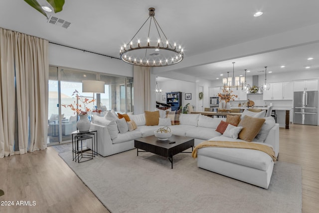 living room featuring recessed lighting, visible vents, a notable chandelier, and light wood finished floors