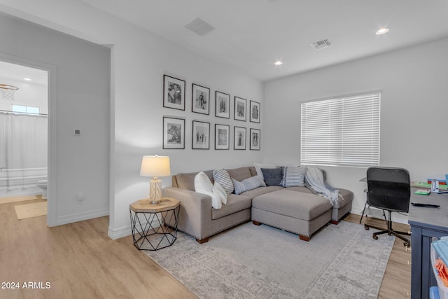 living area with recessed lighting, wood finished floors, visible vents, and baseboards