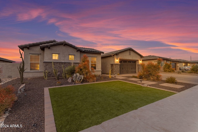 view of front of property featuring an attached garage, a tile roof, a front yard, stucco siding, and driveway