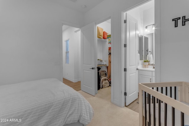 bedroom with a spacious closet and light colored carpet