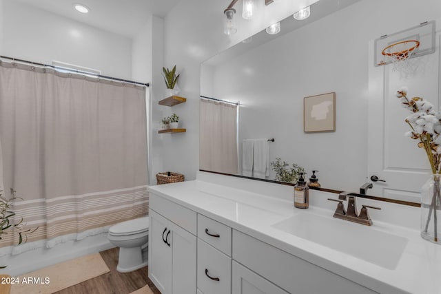 bathroom featuring shower / tub combo with curtain, toilet, wood finished floors, and vanity