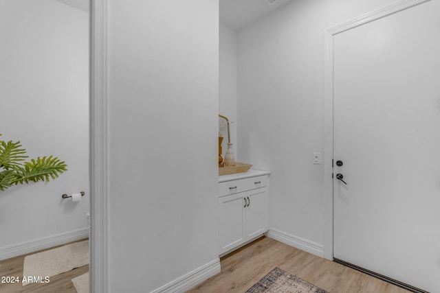 bathroom with vanity, wood finished floors, and baseboards