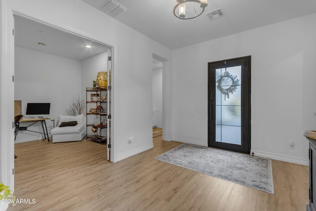 entryway with a notable chandelier, visible vents, baseboards, and light wood-style floors