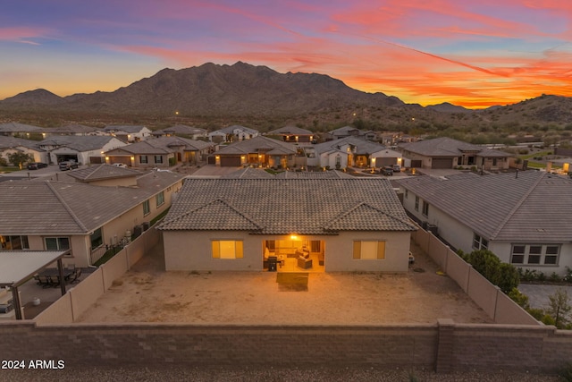 view of front of property with a residential view, stucco siding, a tiled roof, and a fenced backyard