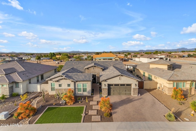 view of front of home featuring a garage, a residential view, stucco siding, and decorative driveway