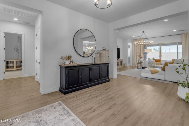 interior space featuring light wood finished floors, visible vents, baseboards, recessed lighting, and an inviting chandelier