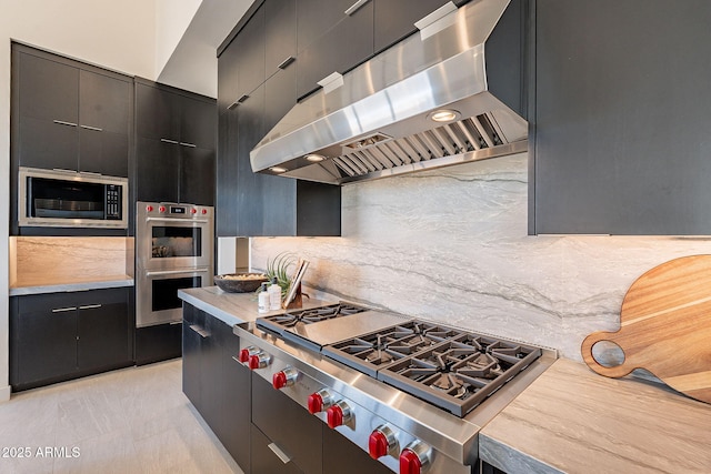 kitchen featuring appliances with stainless steel finishes, exhaust hood, and backsplash