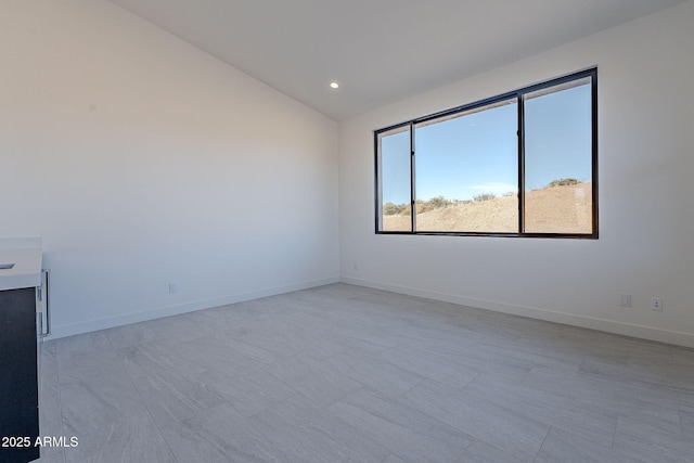 spare room featuring lofted ceiling