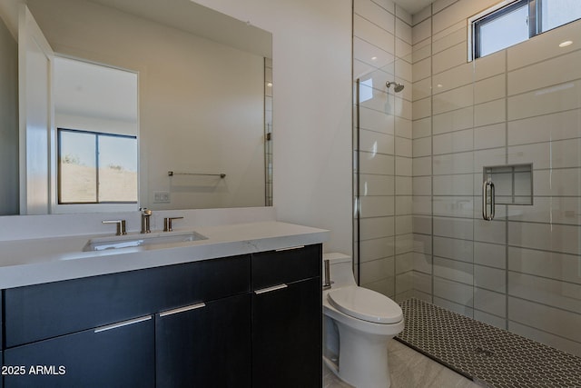 bathroom with toilet, vanity, and a shower with shower door