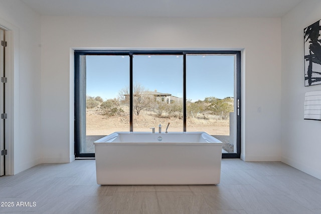 bathroom featuring a bathtub and a wealth of natural light