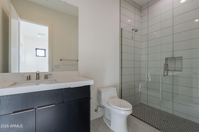 bathroom featuring vanity, wood-type flooring, toilet, and walk in shower