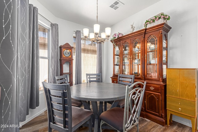 dining room featuring dark hardwood / wood-style flooring, an inviting chandelier, and a healthy amount of sunlight