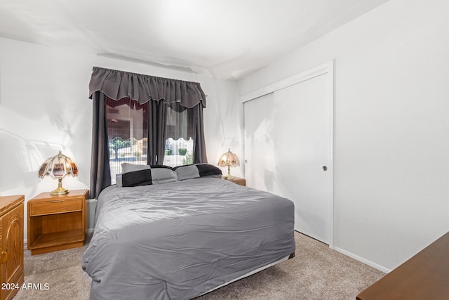 bedroom featuring light carpet and a closet