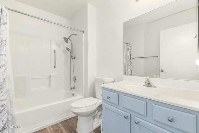 full bathroom with shower / tub combo with curtain, toilet, hardwood / wood-style flooring, and vanity