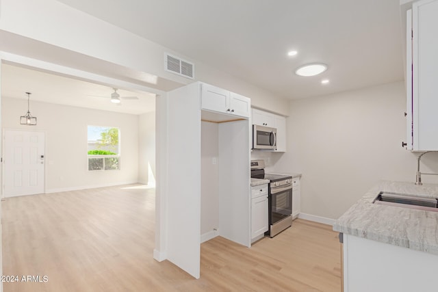 kitchen featuring hanging light fixtures, ceiling fan, appliances with stainless steel finishes, white cabinetry, and light wood-type flooring