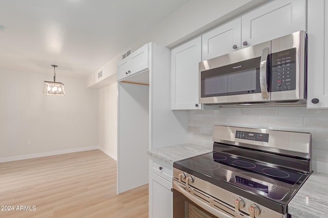 kitchen with decorative backsplash, white cabinets, and stainless steel appliances