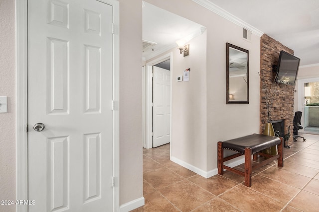 hallway featuring crown molding and light tile patterned flooring