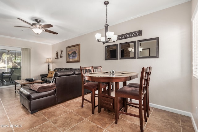 dining room with ceiling fan with notable chandelier and crown molding