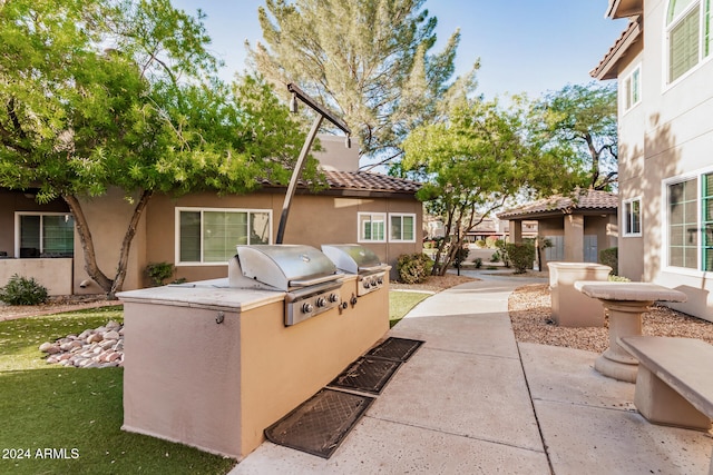 view of patio with an outdoor kitchen and a grill