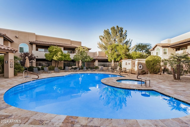 view of pool featuring a patio and a hot tub