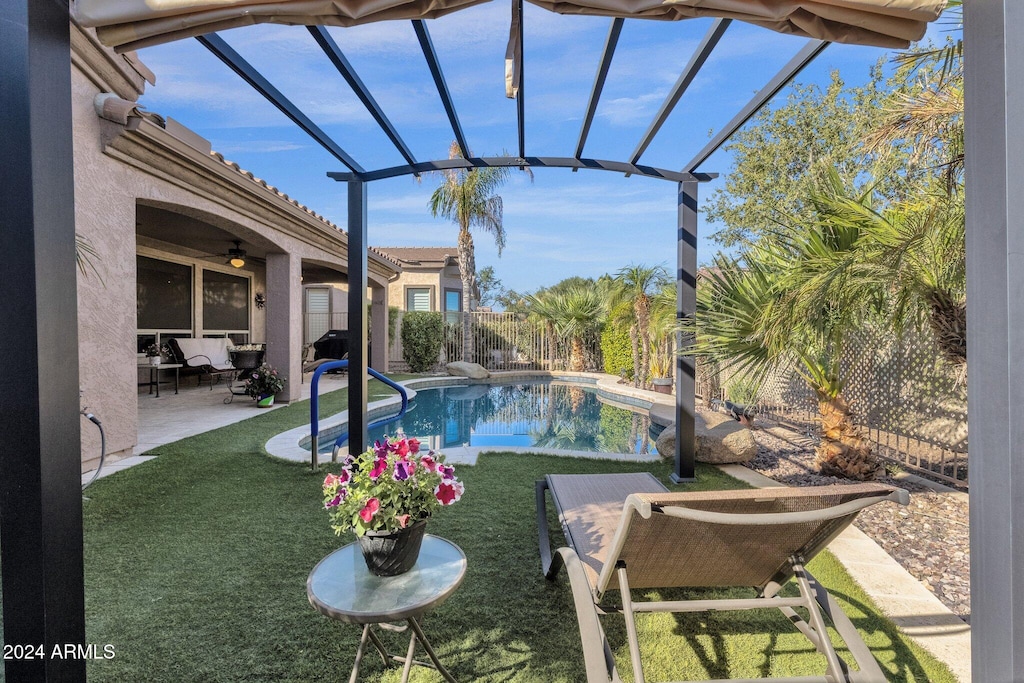 view of pool featuring a lawn, ceiling fan, a lanai, and a patio area