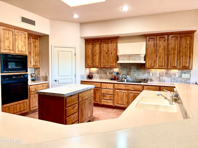 kitchen with a center island, sink, black appliances, backsplash, and light tile patterned floors