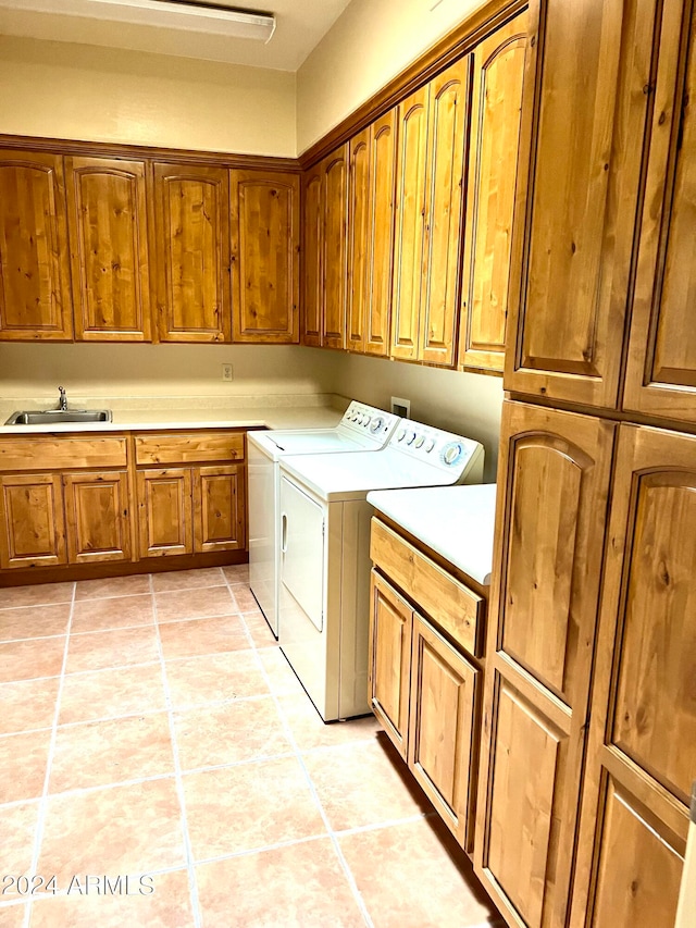 washroom with separate washer and dryer, sink, light tile patterned floors, and cabinets