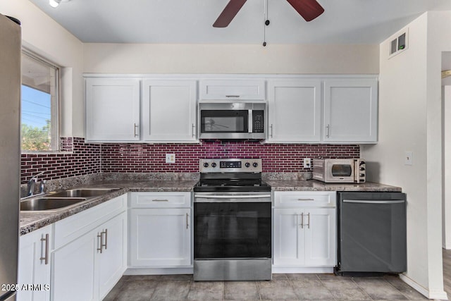 kitchen featuring stainless steel appliances, a sink, visible vents, and white cabinets