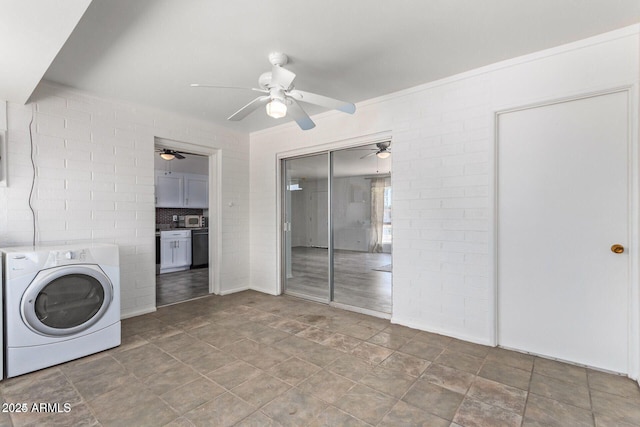clothes washing area featuring laundry area, brick wall, washer / clothes dryer, and a ceiling fan