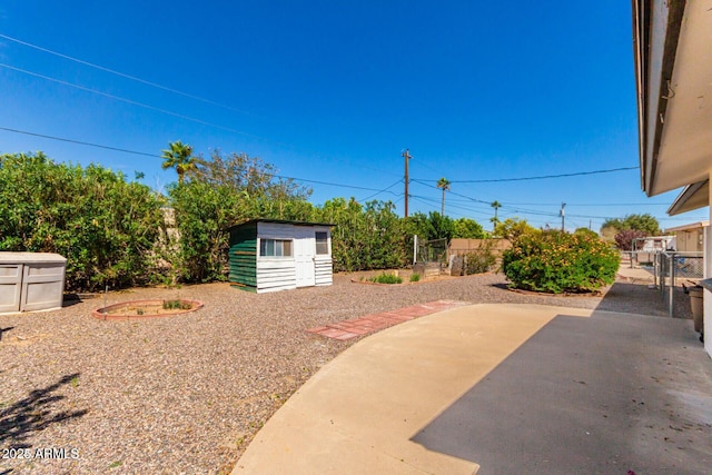 view of yard featuring an outbuilding, a shed, a patio area, and a fenced backyard