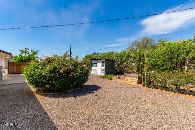 view of yard featuring an outbuilding and fence