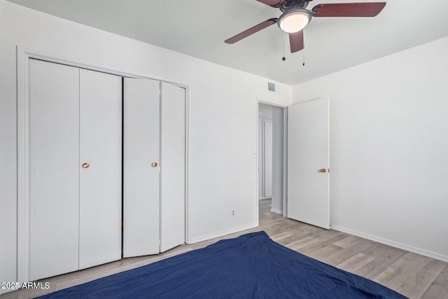 unfurnished bedroom with ceiling fan, visible vents, baseboards, a closet, and light wood-type flooring