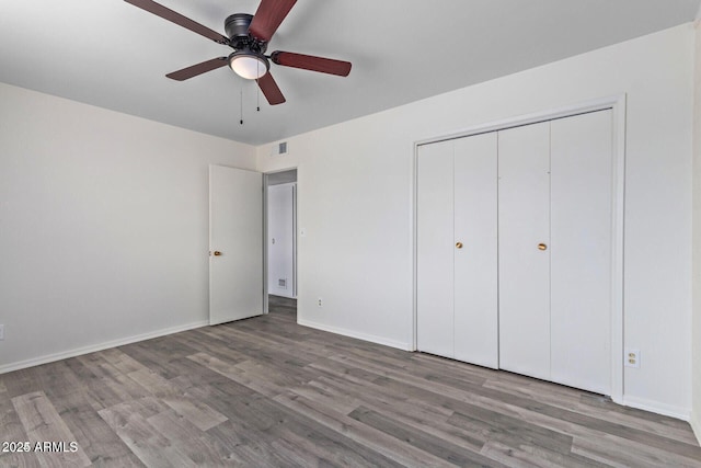 unfurnished bedroom featuring ceiling fan, a closet, light wood-type flooring, and baseboards