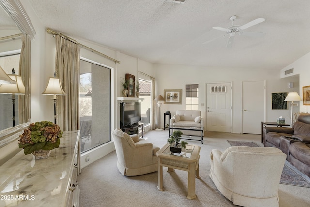 living room with vaulted ceiling, light carpet, ceiling fan, and a textured ceiling