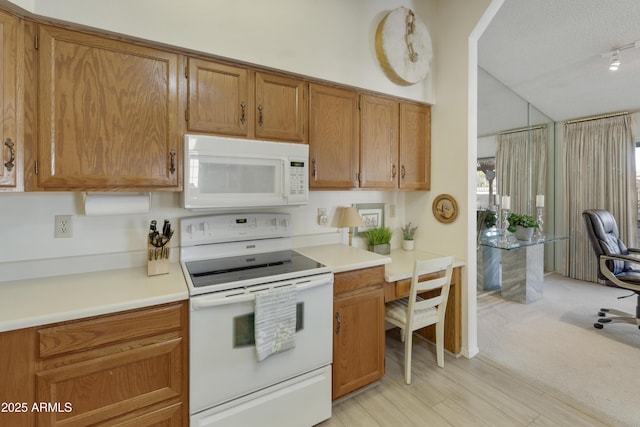 kitchen featuring lofted ceiling, a textured ceiling, and white appliances