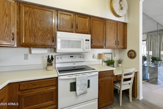 kitchen with white appliances and light hardwood / wood-style flooring