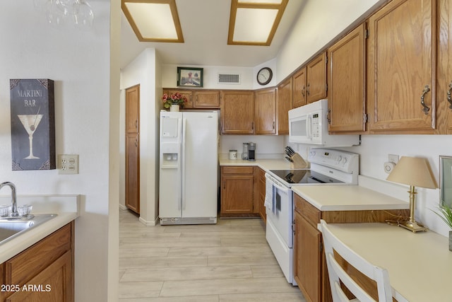 kitchen featuring sink, white appliances, and light hardwood / wood-style floors