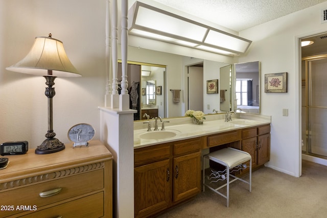 bathroom with vanity, a shower with door, and a textured ceiling