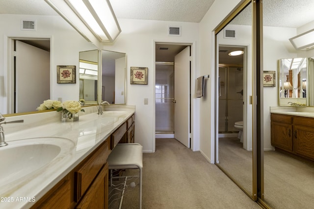 bathroom with vanity, an enclosed shower, a textured ceiling, and toilet