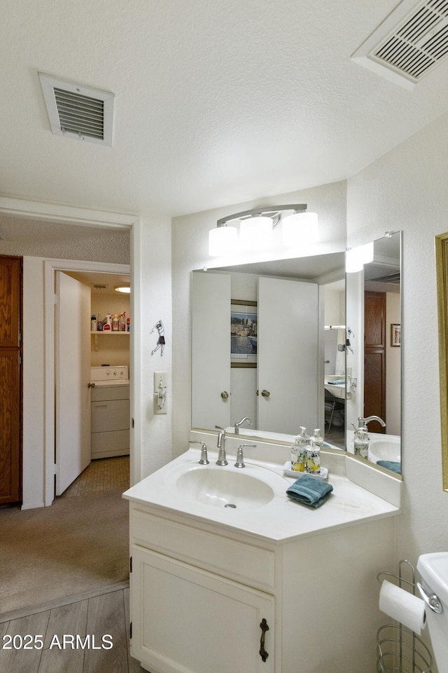 bathroom featuring vanity, washer / dryer, and wood-type flooring