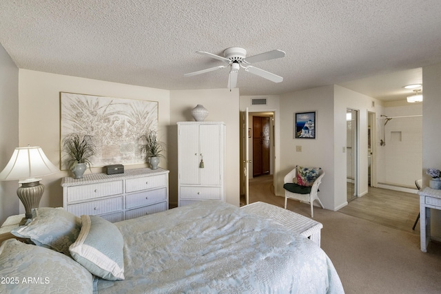 bedroom featuring ceiling fan, light carpet, a textured ceiling, and a baseboard heating unit