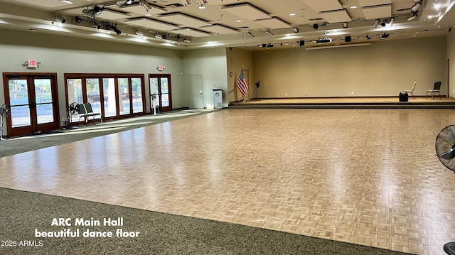 exercise room featuring rail lighting and french doors