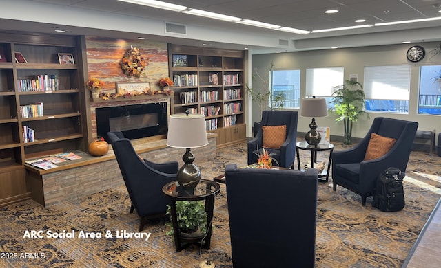 sitting room with a large fireplace and built in features