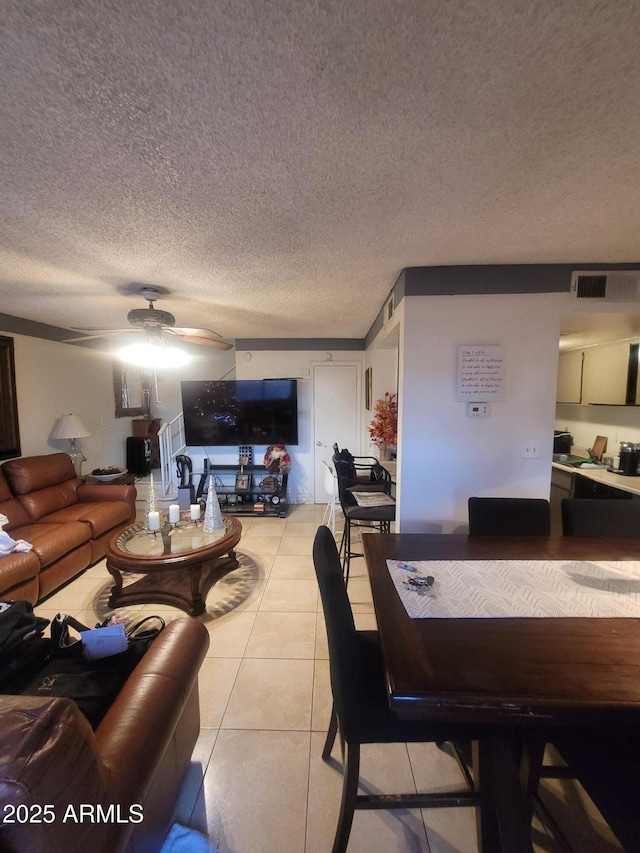 tiled dining area with a textured ceiling and ceiling fan