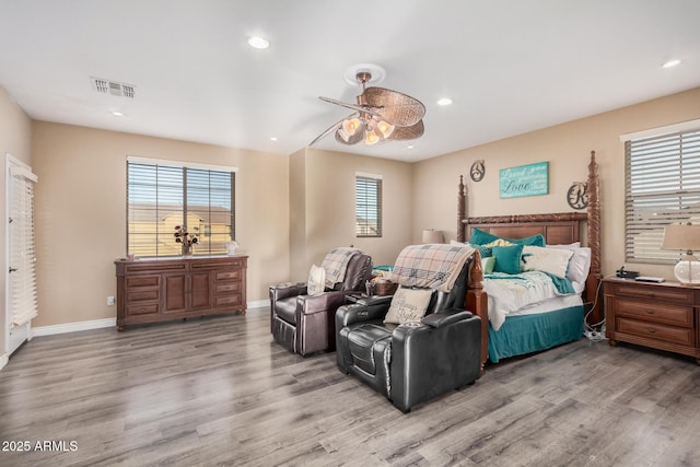 bedroom with light wood-type flooring, multiple windows, and ceiling fan