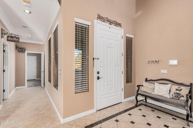 entryway with crown molding and light tile patterned floors