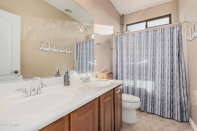 bathroom with tile patterned floors, toilet, vanity, and lofted ceiling