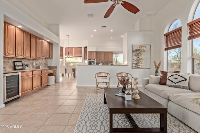 living room with ceiling fan, light tile patterned floors, wine cooler, and a healthy amount of sunlight