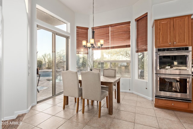 tiled dining space featuring a chandelier and a wealth of natural light