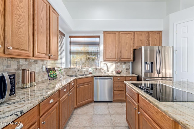 kitchen featuring light stone counters, stainless steel appliances, light tile patterned floors, backsplash, and sink